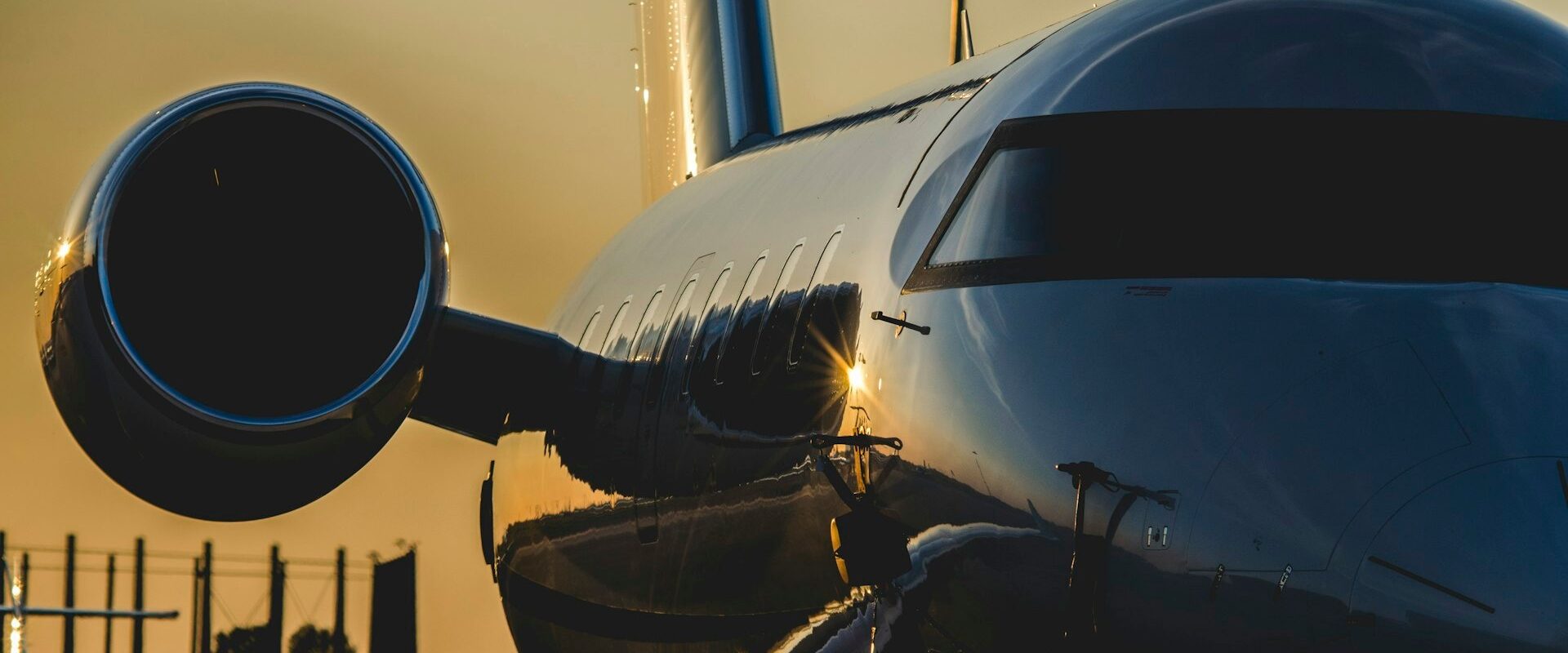 download ► Charter-A Ltd Charter-a ltd close-up of a polished jet with its engine nacelle on the left and cockpit window at sunset, reflecting warm light on the fuselage.